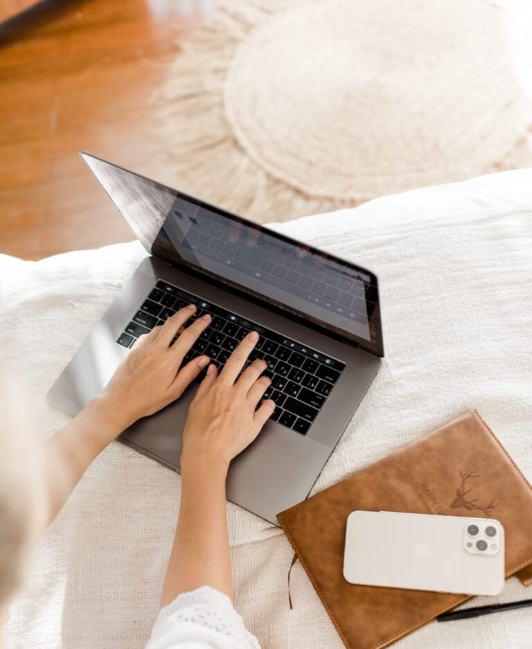 Eine Person, die bequem an einem Laptop arbeitet, auf einer gemütlichen gewebten Matte sitzt und eine ruhige, minimalistische häusliche Umgebung genießt, während sie Blitzcoaching betreibt.